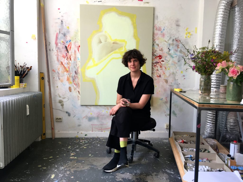 Die Malerin Vivien Greten sitzt vor einem ihrer Bilder in ihrem Atelier in Düsseldorf.